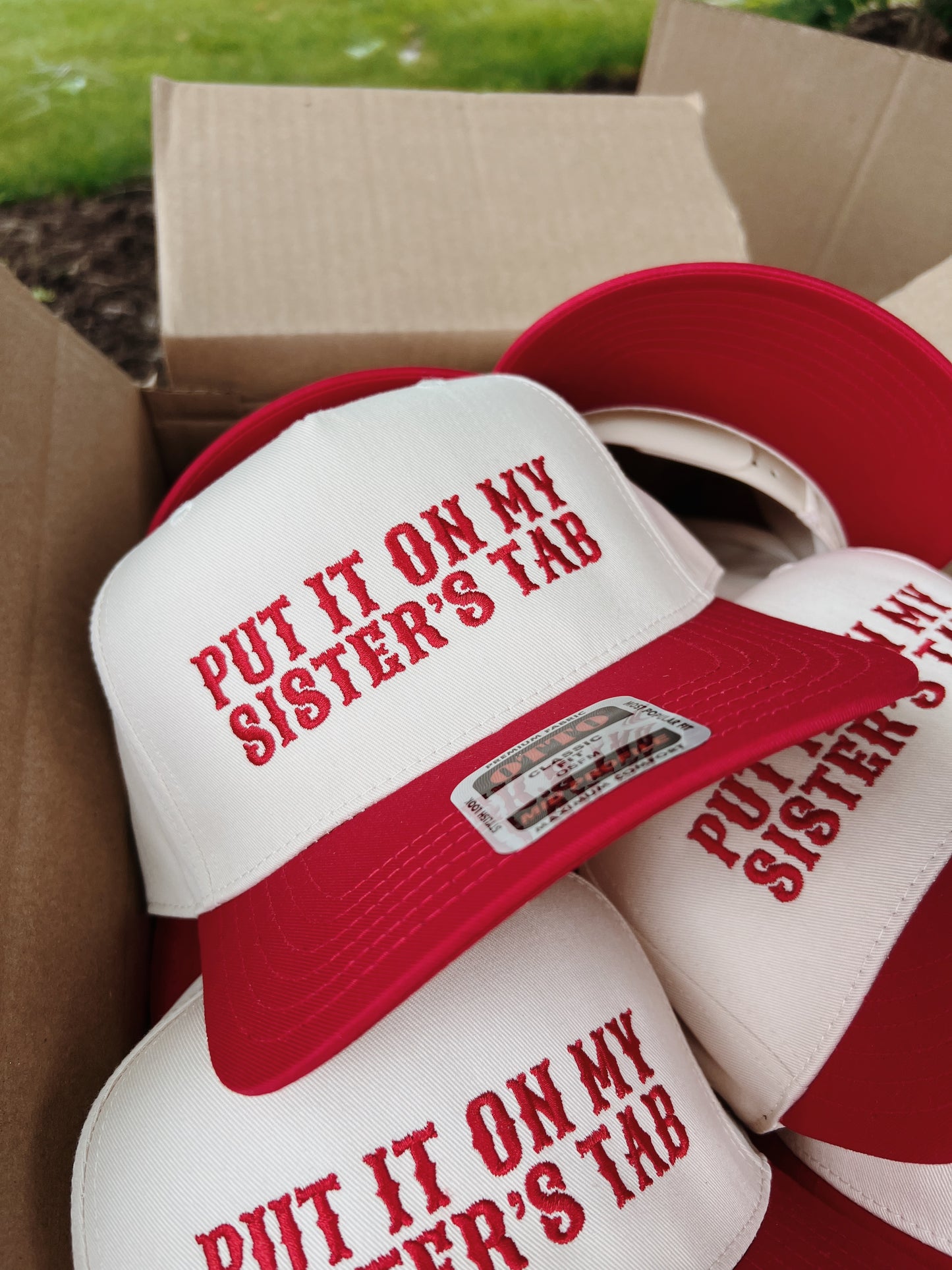 Put It On My Sisters Tab Trucker Hat